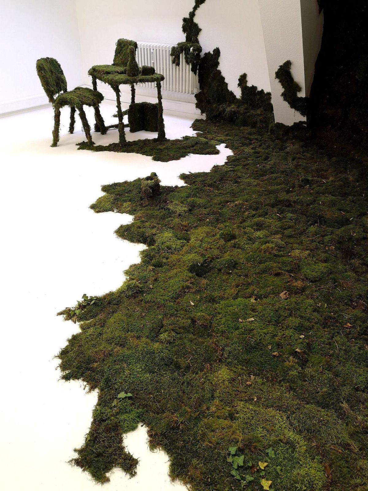 two chairs and a table covered in moss