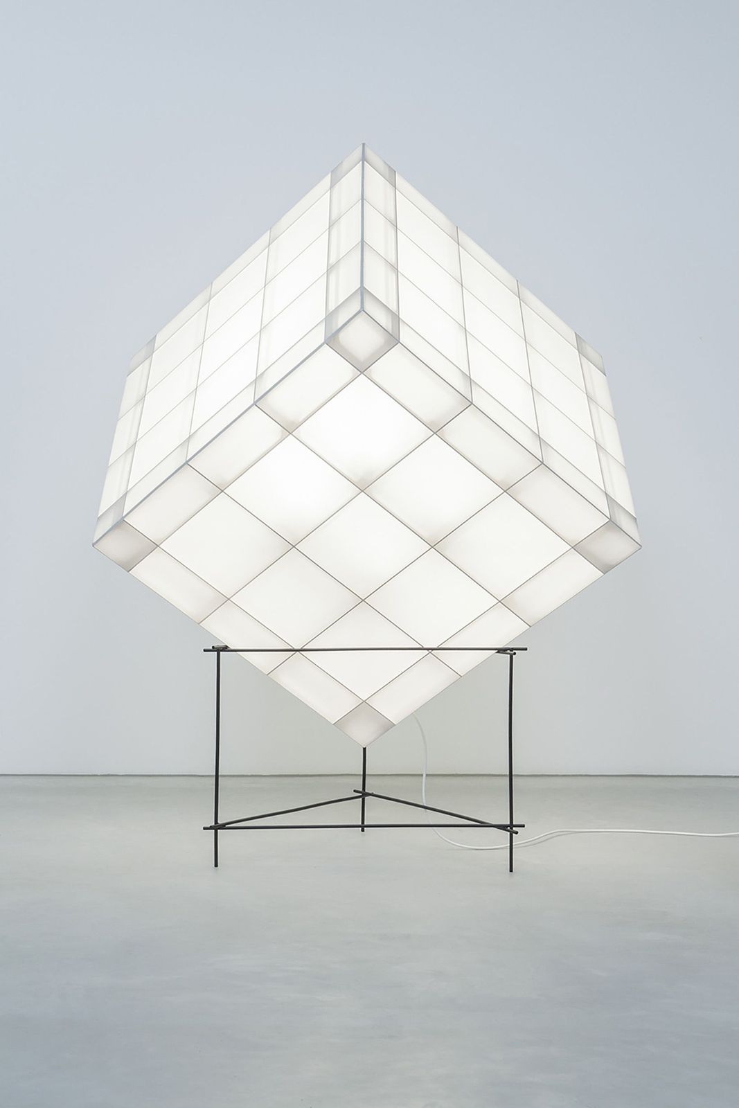 a large white cube sitting on top of a metal stand