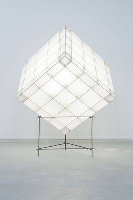 a large white cube sitting on top of a metal stand