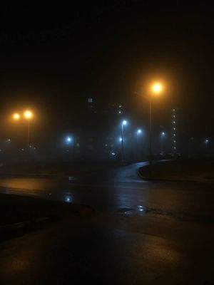 a foggy night with street lights and street lights