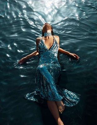 a woman in a blue dress floating in the water