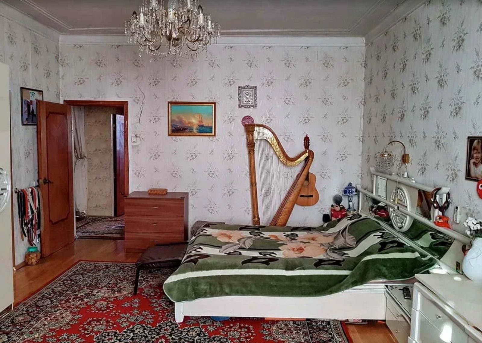 a bed room with a bed a dresser and a harp