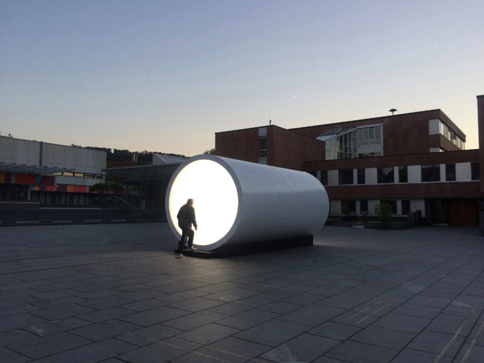 a man standing in front of a large white object