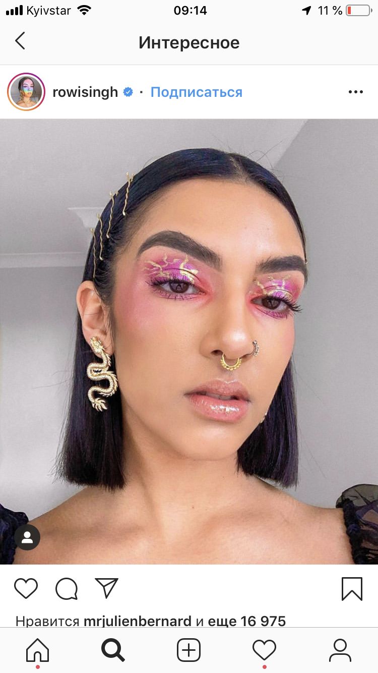 a woman with pink makeup and piercings on her face