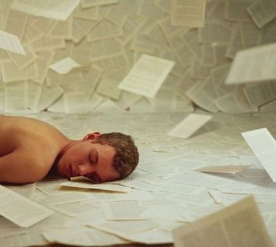 a young man sleeping on a sheet of paper