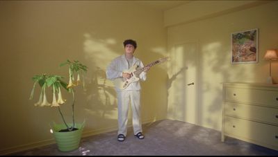 a man standing in a room with a guitar