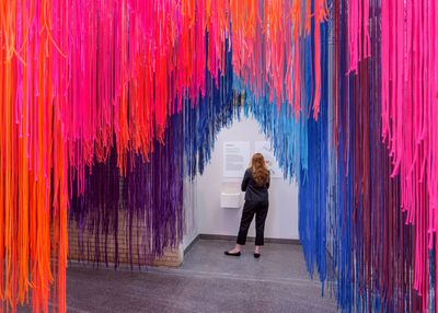 a woman standing in front of a colorful wall