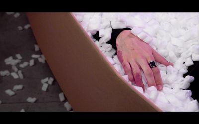 a person's hand resting on a pile of cotton