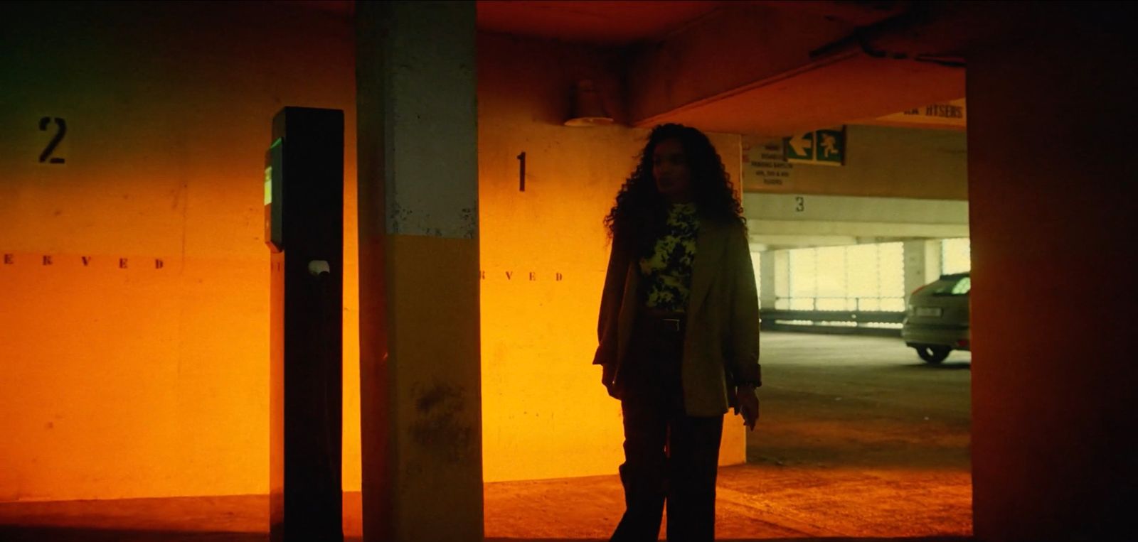 a woman standing in an empty parking garage