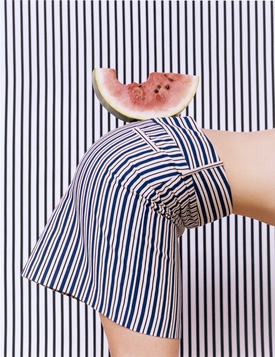 a woman with a watermelon slice on her head