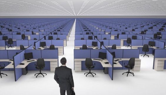 a man standing in front of a row of desks