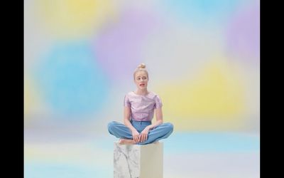 a young girl sitting on top of a white box