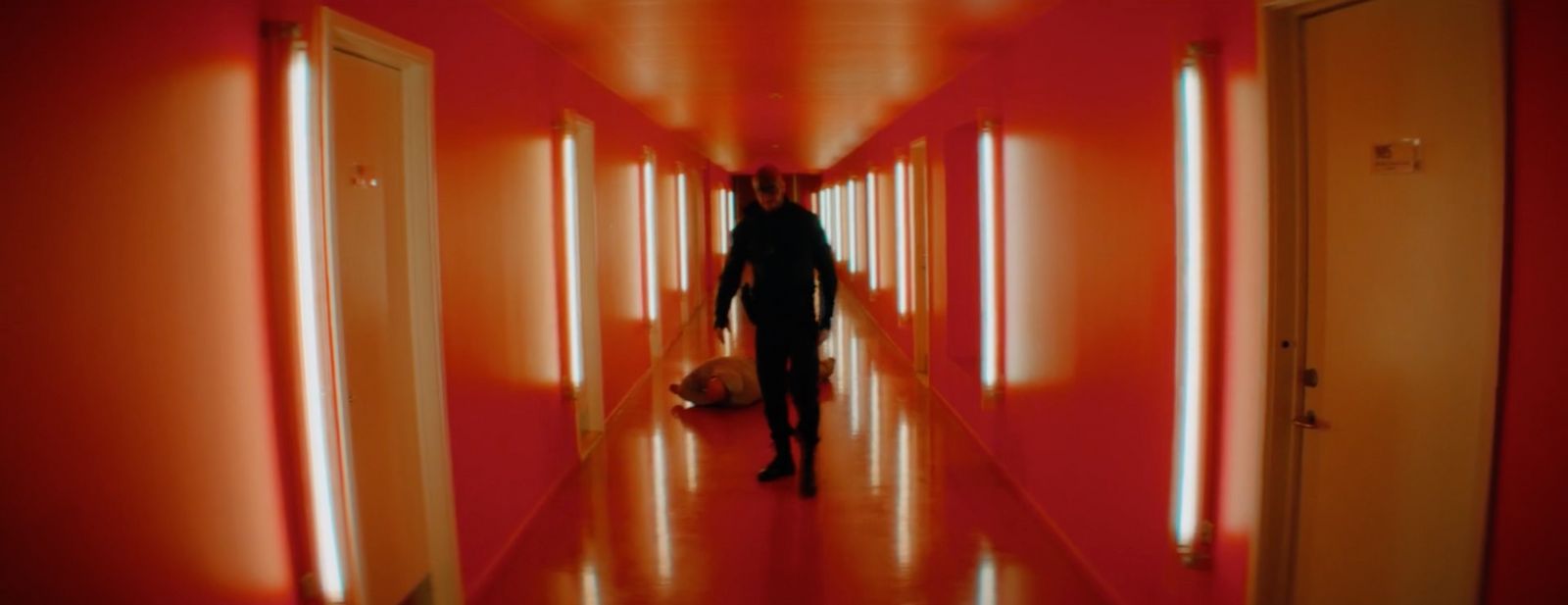 a man is walking down a long hallway