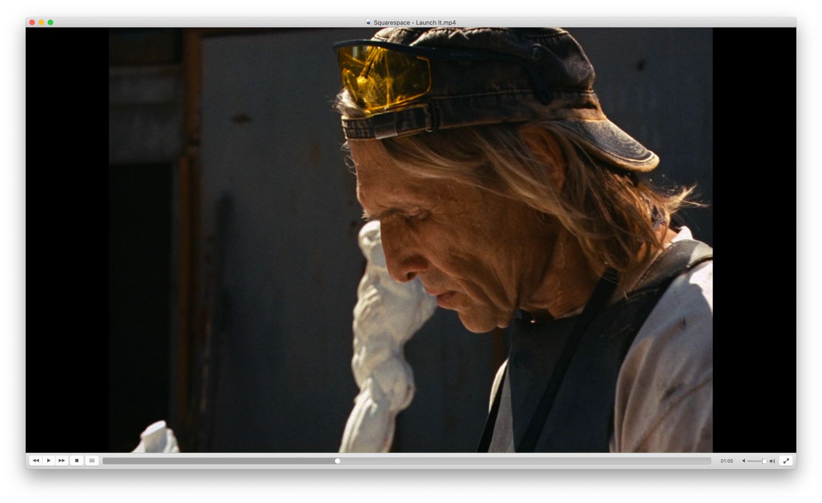 a man wearing a hat and goggles smoking a cigarette