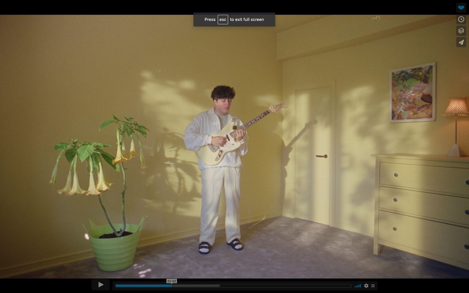 a man standing in a room playing a guitar