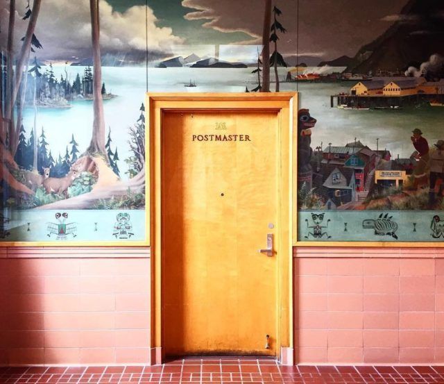 a yellow door is open in front of a mural