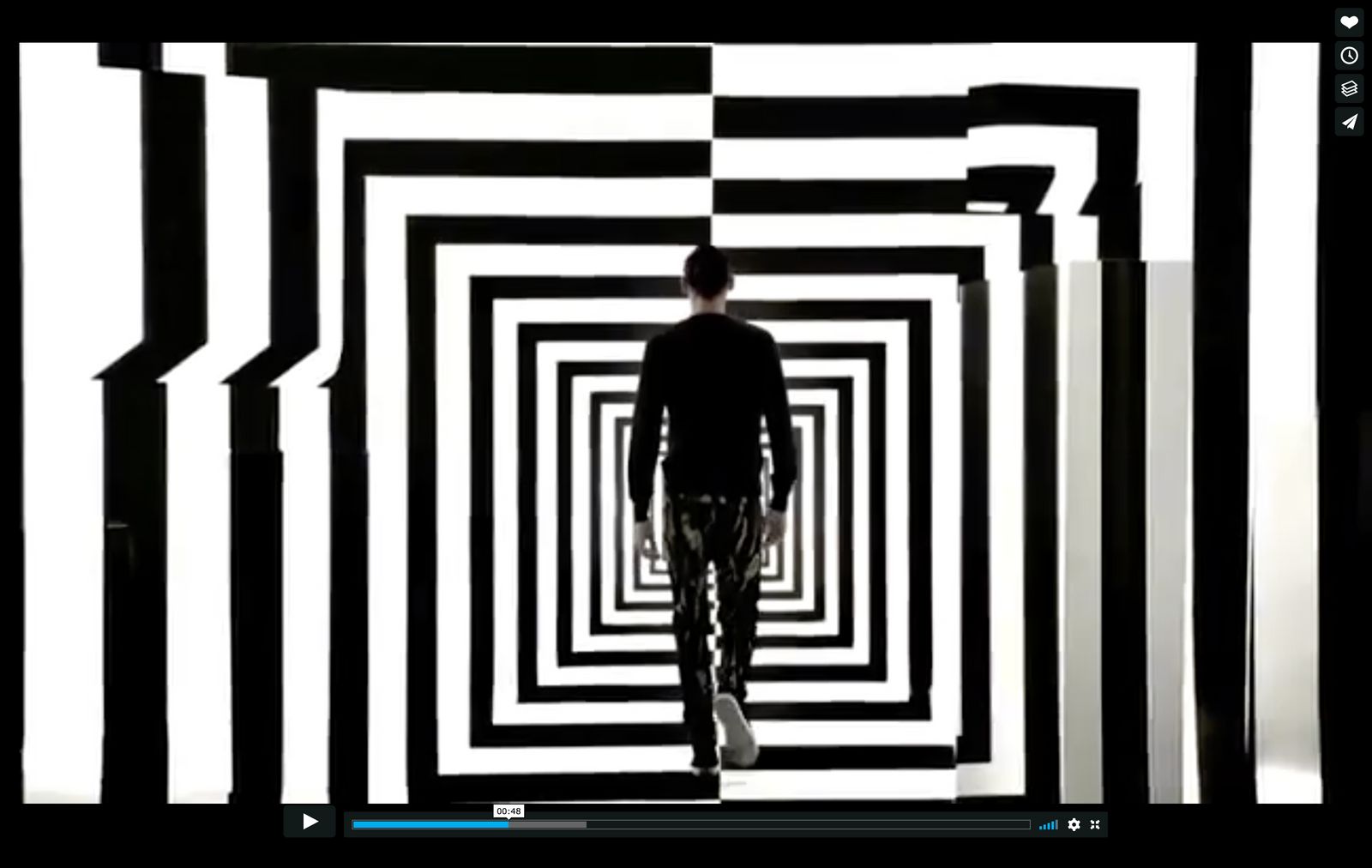 a man walking through a black and white tunnel