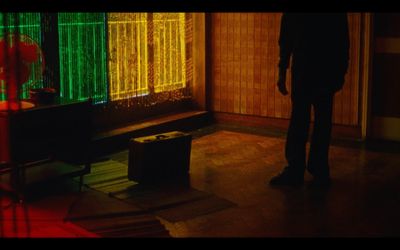 a man standing in front of a window in a dark room