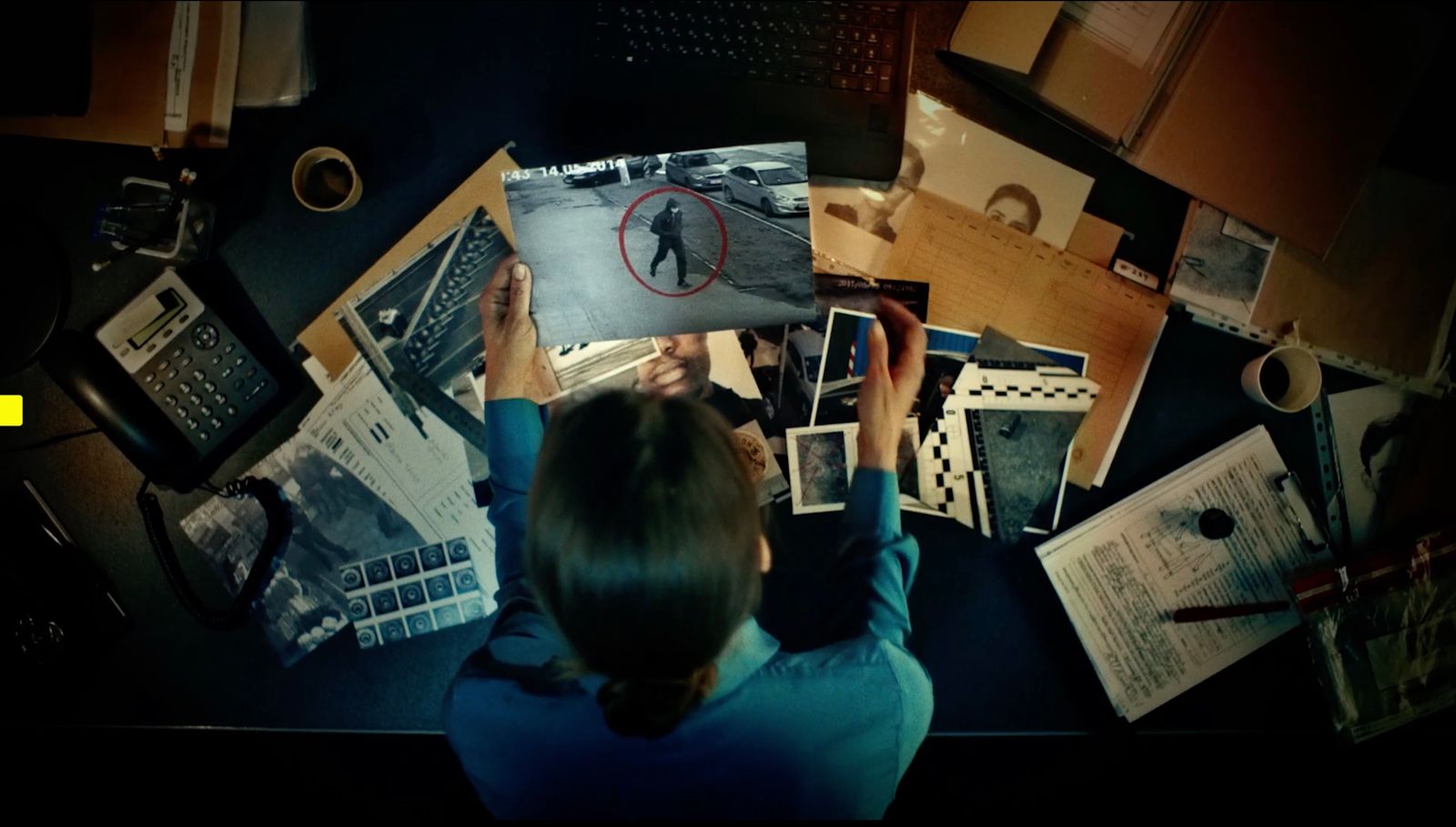 a woman sitting at a desk with a lot of papers