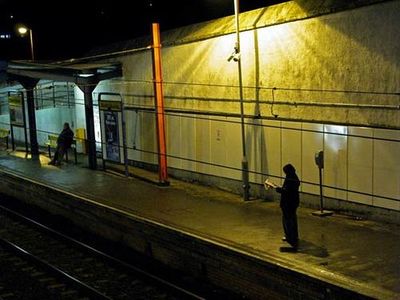 a person standing on a train platform at night