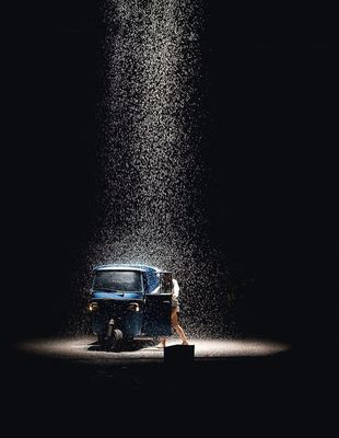 a blue van parked under a rain shower