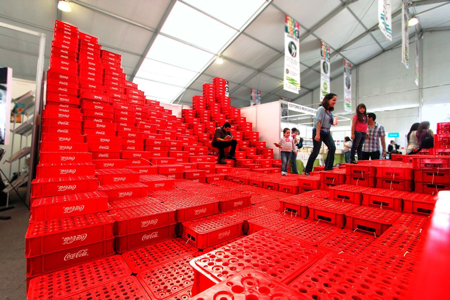 a group of people standing around a room filled with red boxes