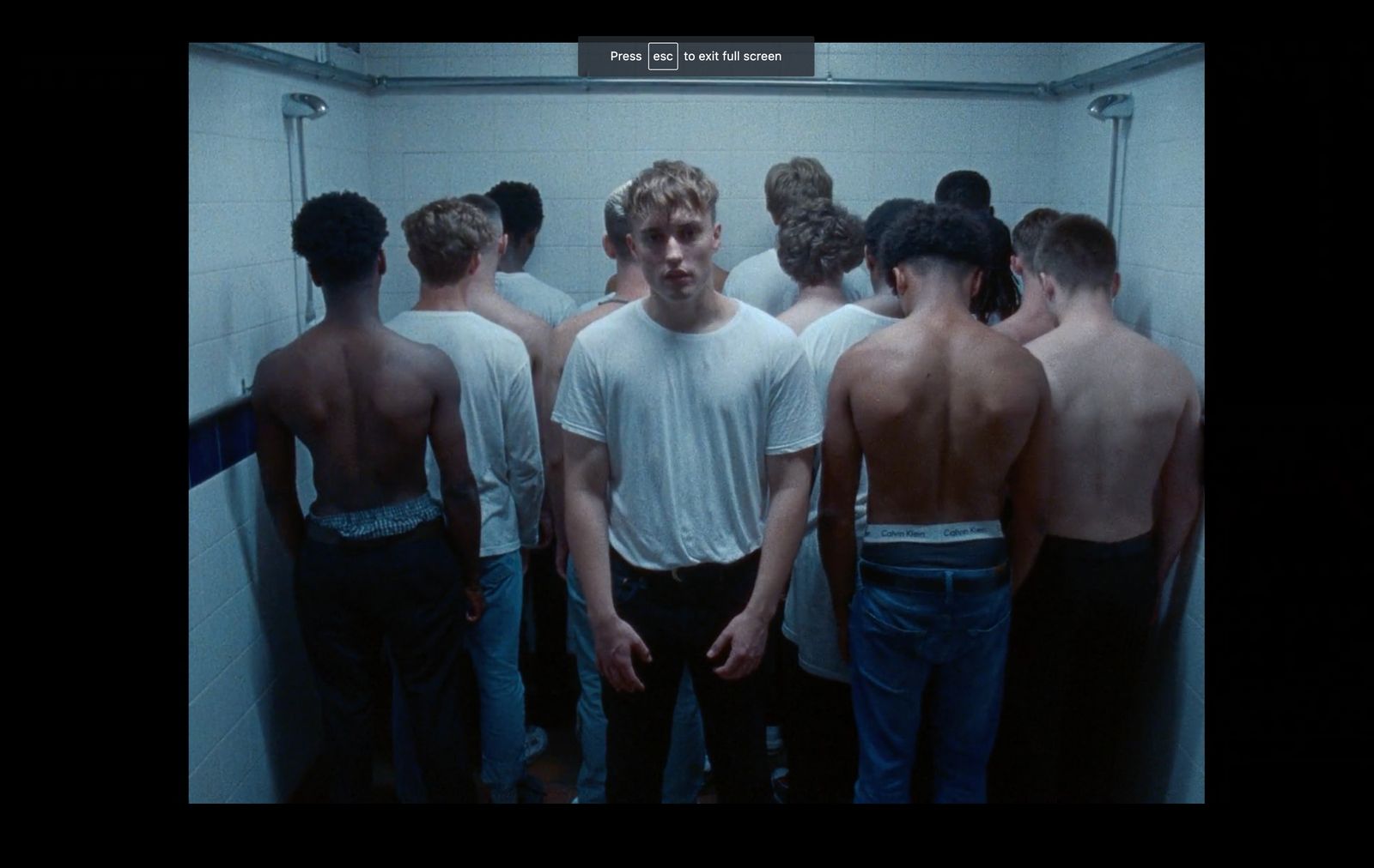 a group of men standing in a bathroom next to each other