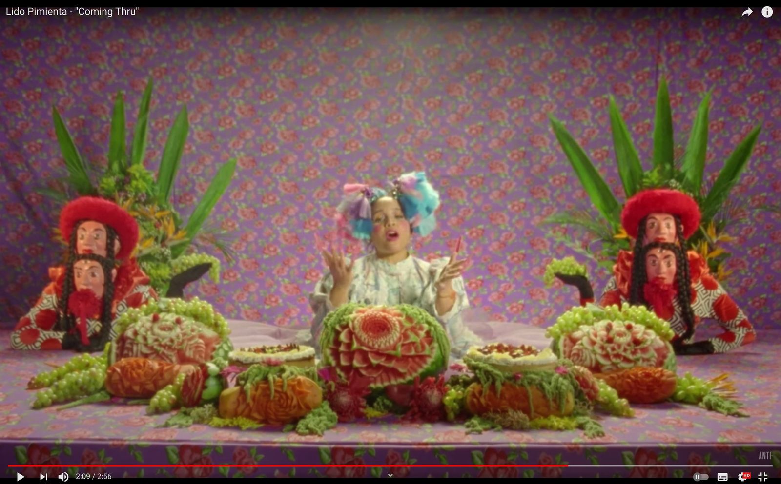 a child sitting in front of a display of fruits and vegetables