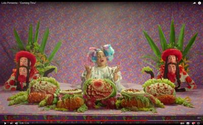 a child sitting in front of a display of fruits and vegetables