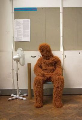 a large brown teddy bear sitting on top of a chair