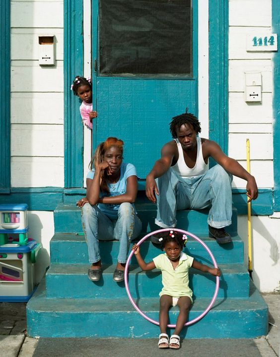 a group of people sitting on the steps of a house