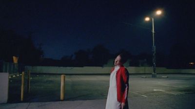 a person standing on a sidewalk at night