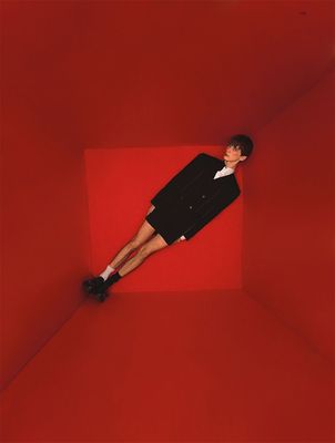 a man in a suit and tie laying on a red floor