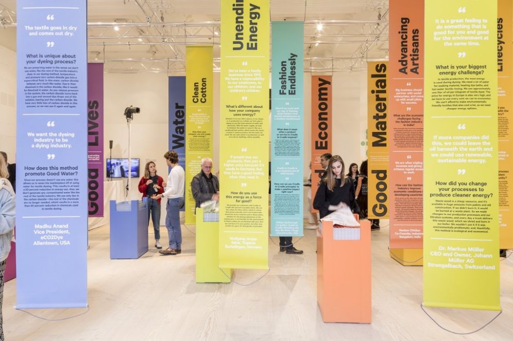 a group of people standing in front of colorful banners