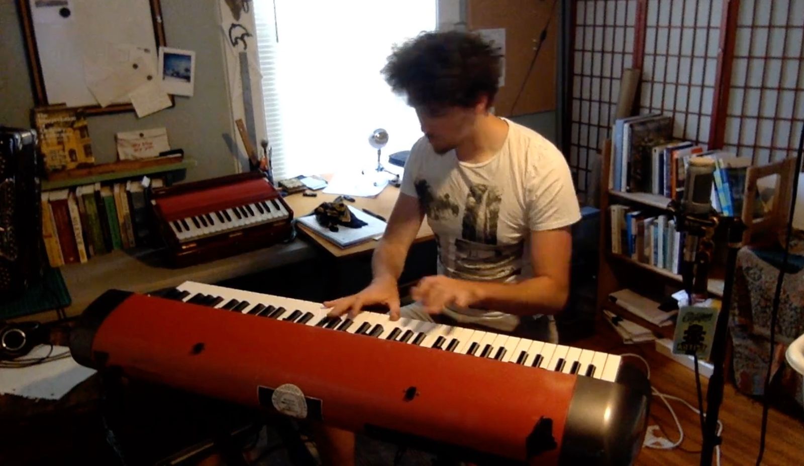 a man sitting at a keyboard in a room