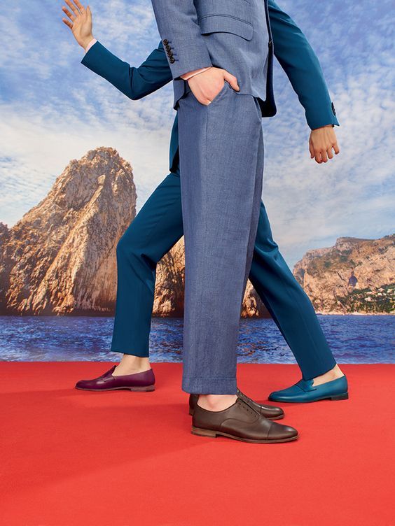 a man in a suit walking on a red carpet