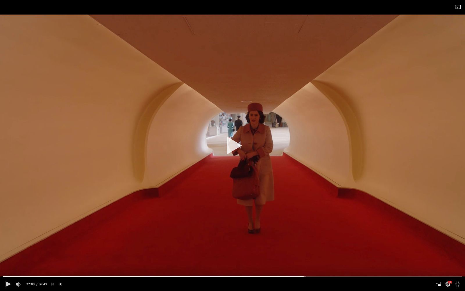 a woman walking down a red carpeted hallway