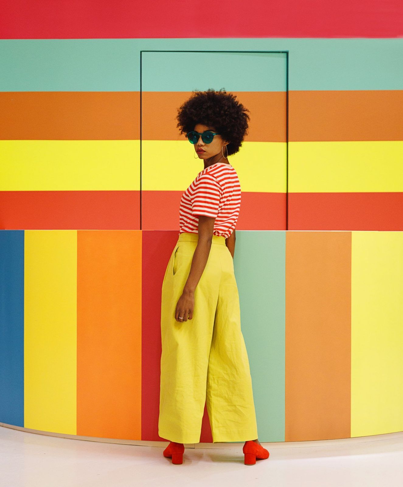 a woman standing in front of a colorful wall