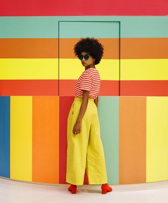 a woman standing in front of a colorful wall