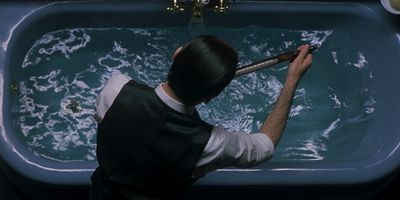 a man washing his hands in a blue bathtub