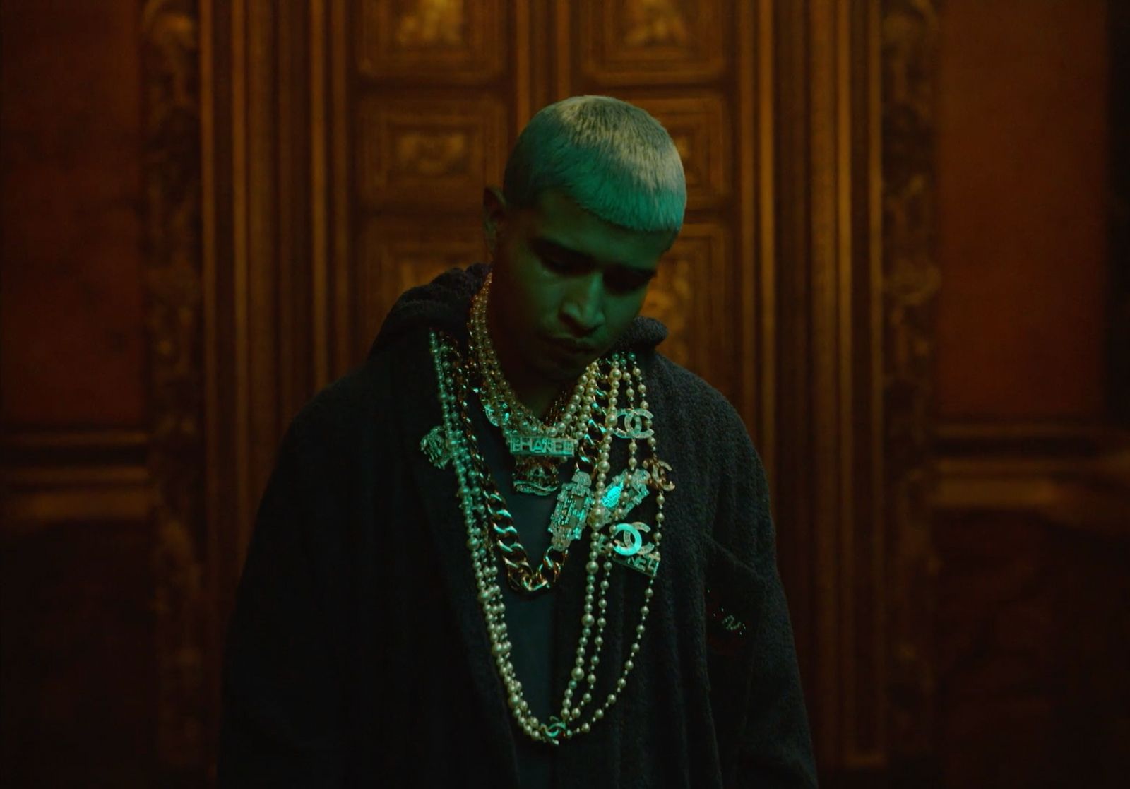 a man with green hair wearing a black jacket