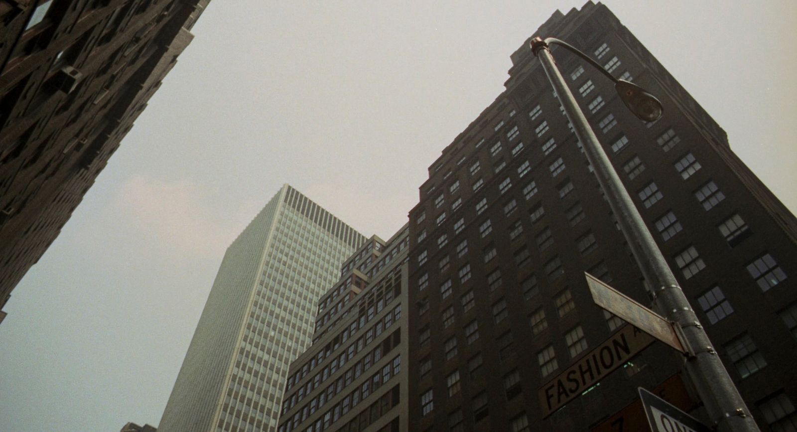 a traffic light and street signs in front of tall buildings