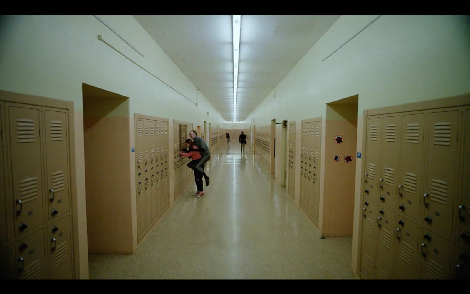 a couple hugging each other in a long hallway