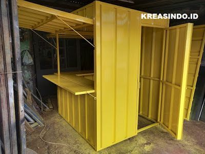 a yellow storage shed with a shelf inside of it