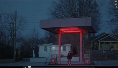 a person standing in front of a gas station