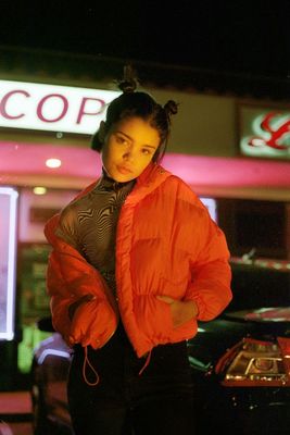 a woman standing in front of a store at night