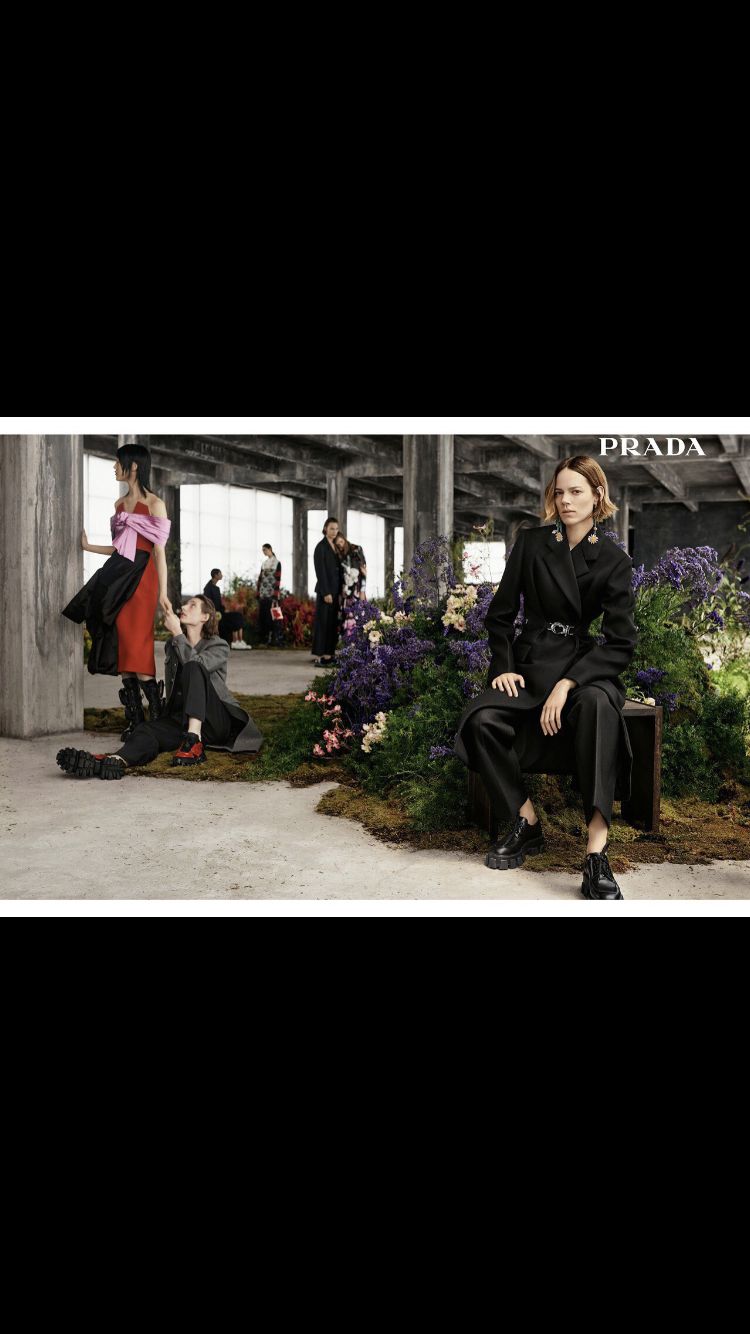 a woman sitting on a bench in front of a group of people