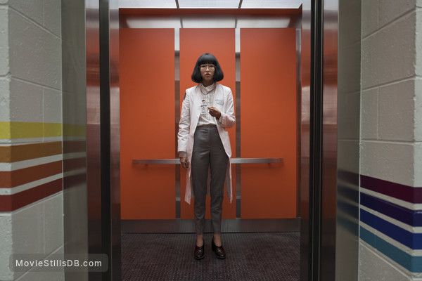 a woman standing in an elevator looking at her cell phone