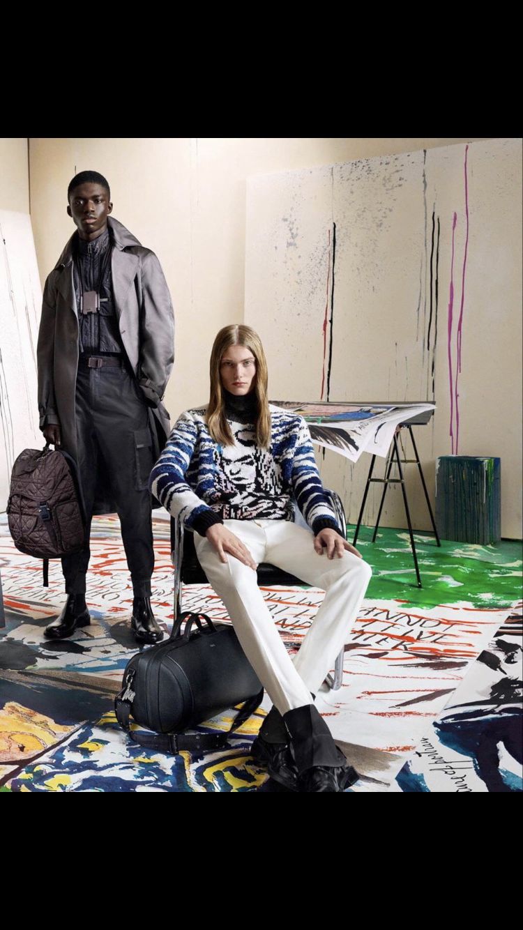 a man and a woman sitting on a chair in an art studio