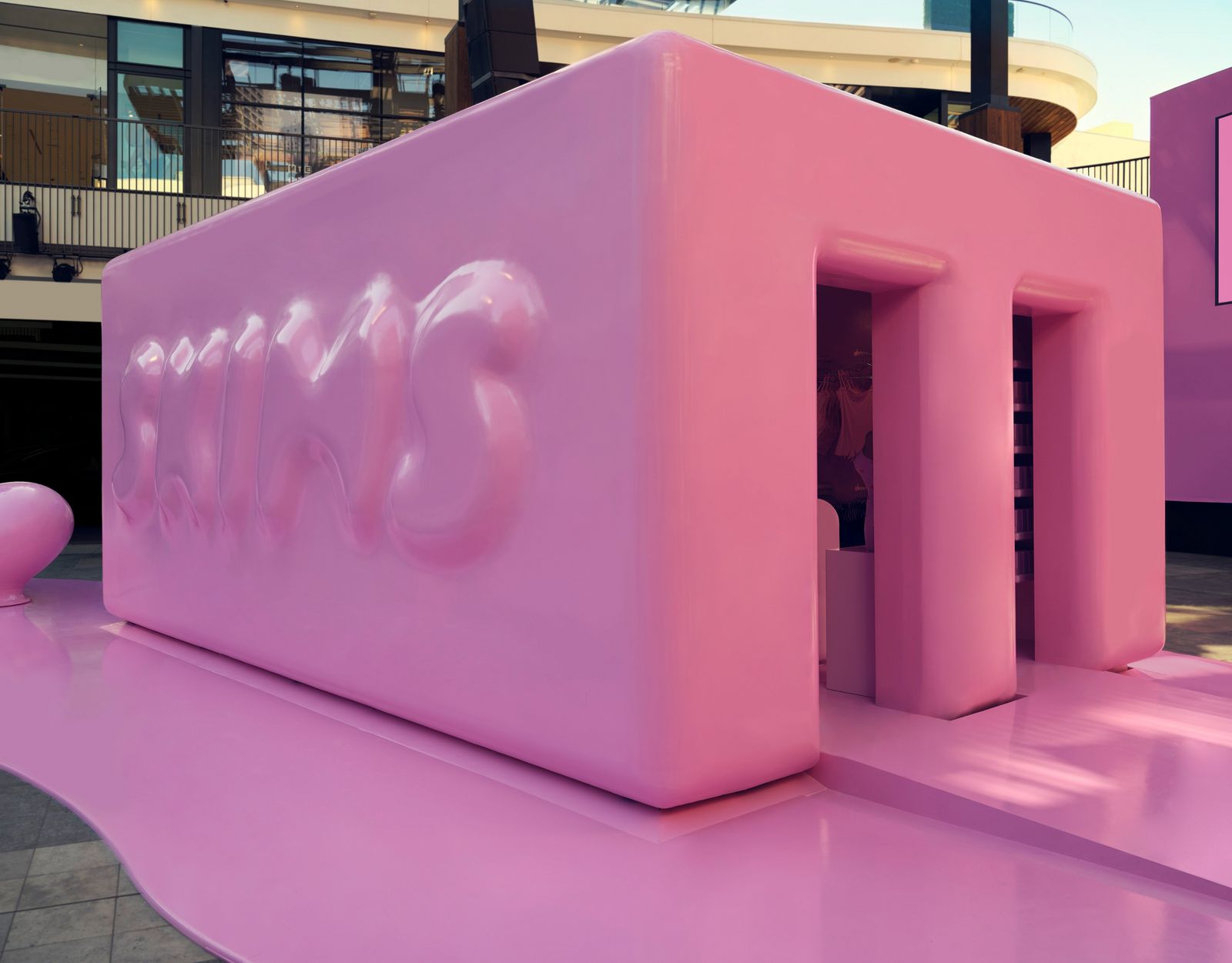 a large pink building with a person entering it